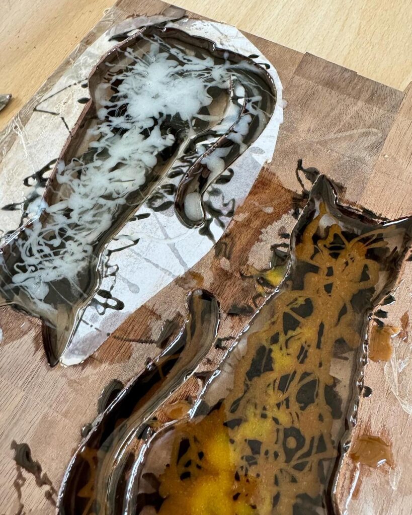 Gieten van de gekleurde epoxy bij de epoxy katten
